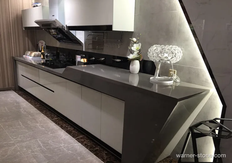 Futuristic modern kitchen featuring sleek dark grey solid quartz with 45-degree mitered geometric waterfall edge