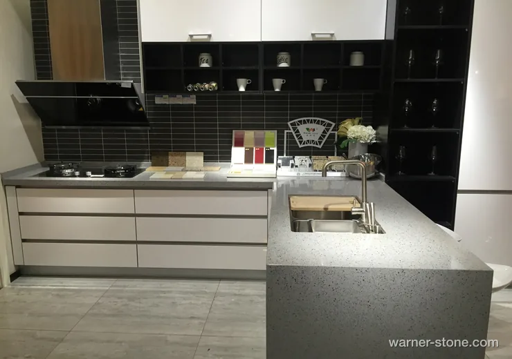 Modern open-concept kitchen featuring light grey crystal quartz countertops and matching food prep island