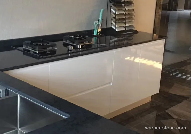Minimalist white lacquer cabinetry contrasted with high-gloss polished black quartz surface